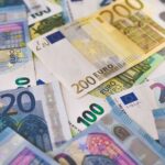 Close-up of various Euro banknotes scattered on a surfa