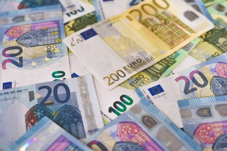 Close-up of various Euro banknotes scattered on a surfa