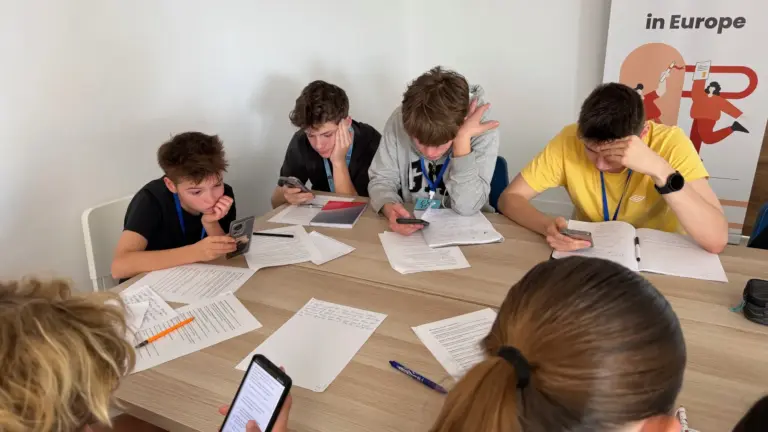 Participants drafting their laws with worksheets and phones
